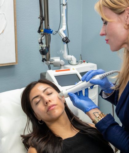 Woman receiving aesthetic treatment from a professional at Luxe Aesthetic Center, showcasing advanced skincare technology and personalized care.