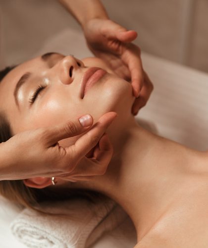 Young woman getting spa treatment with head massage at a spa center